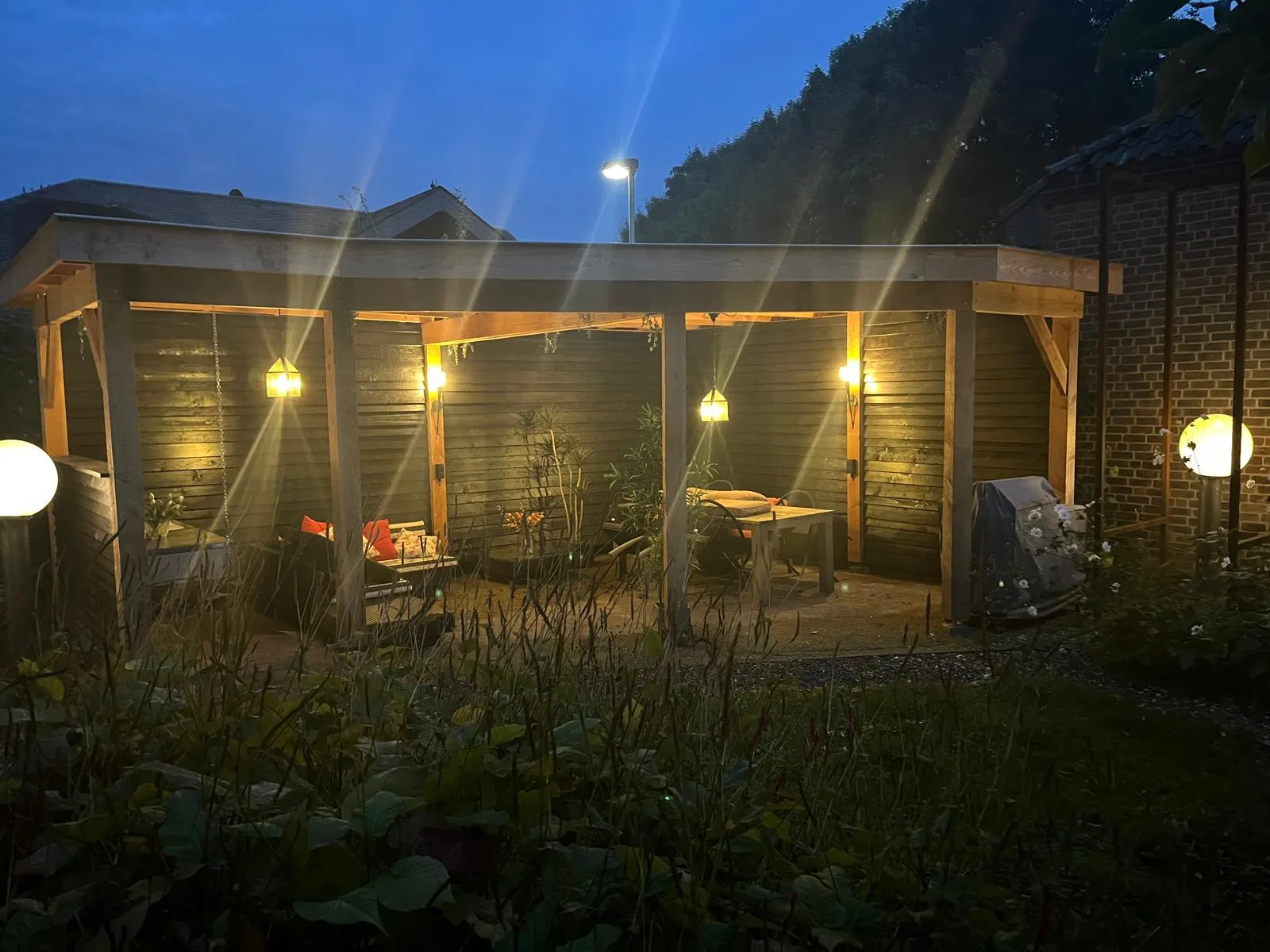 Verlichte veranda met zithoek in de avond